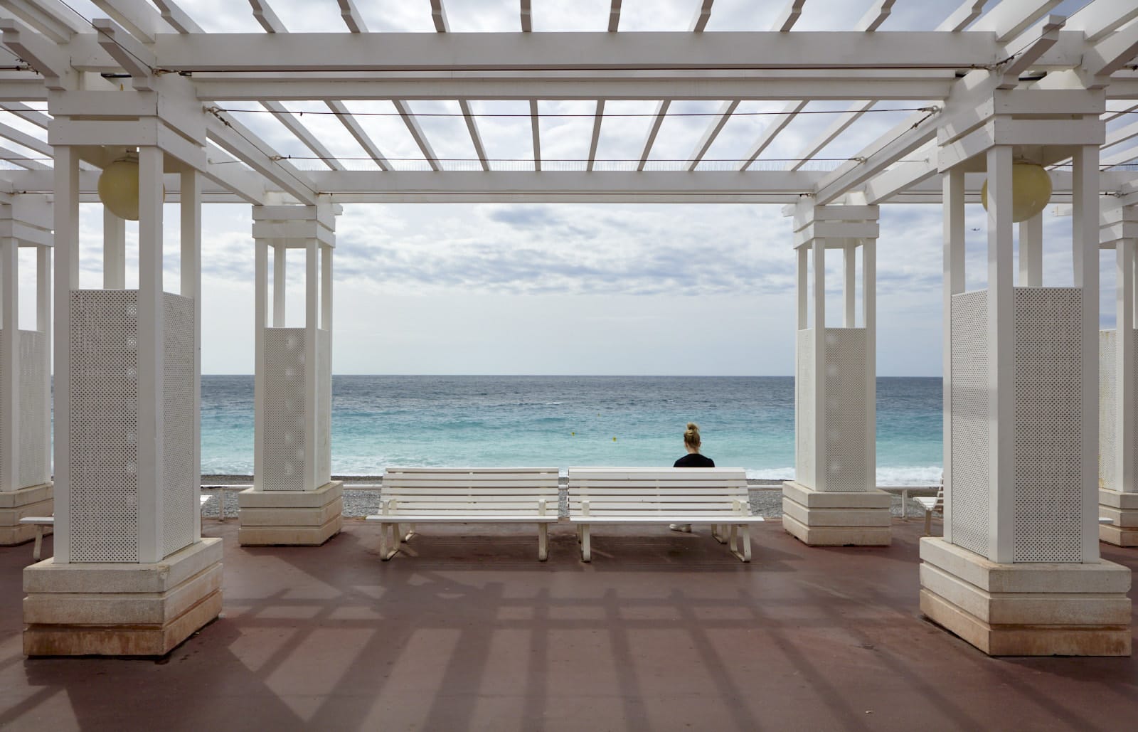pergola with woman in front of sea scape